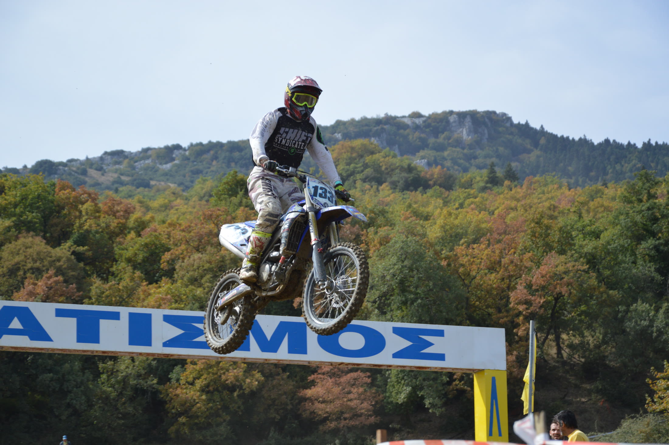 Motocross rider clearing the crest of a mountain race jump